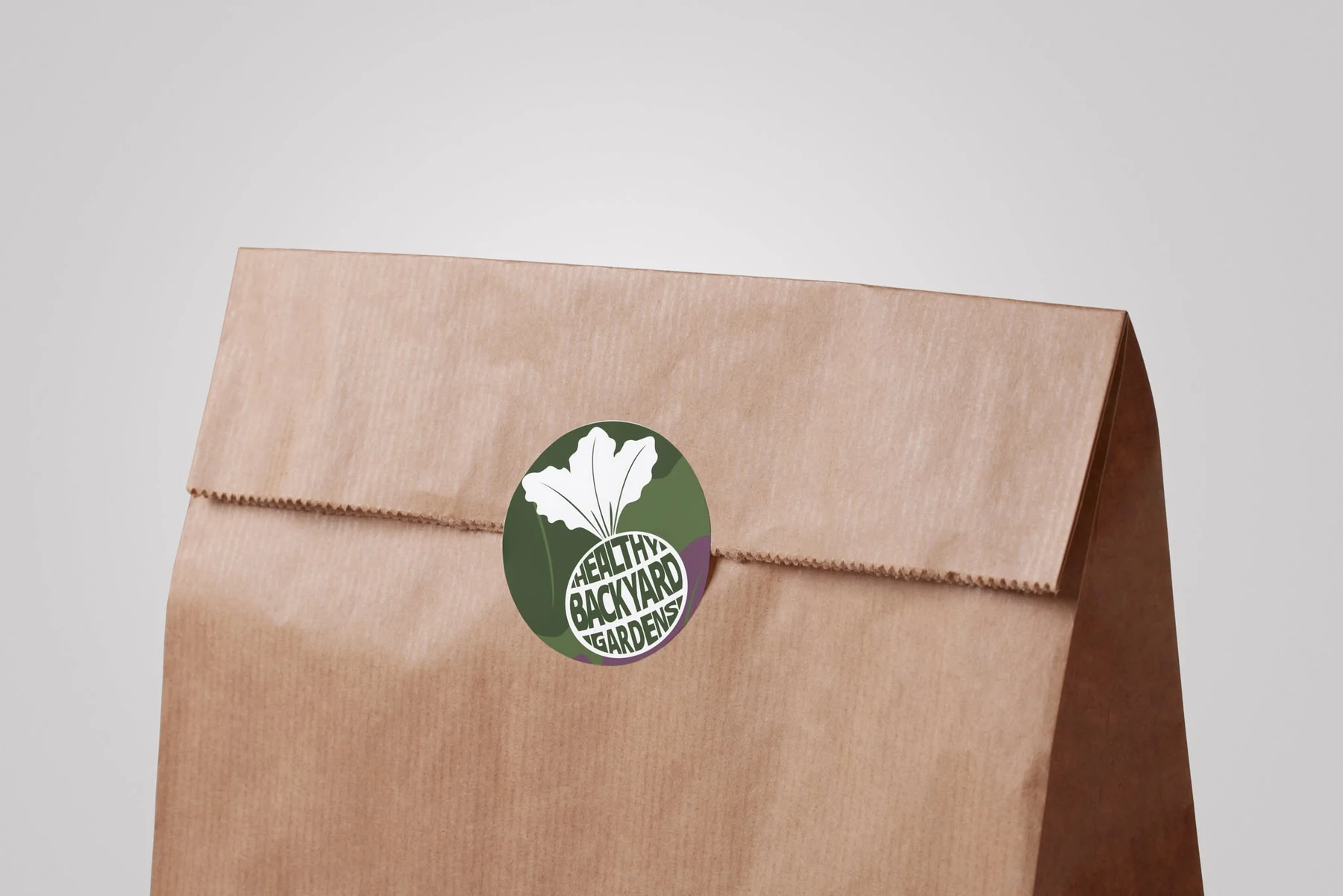 Healthy Backyard Gardens round logo sticker applied to kraft packaging